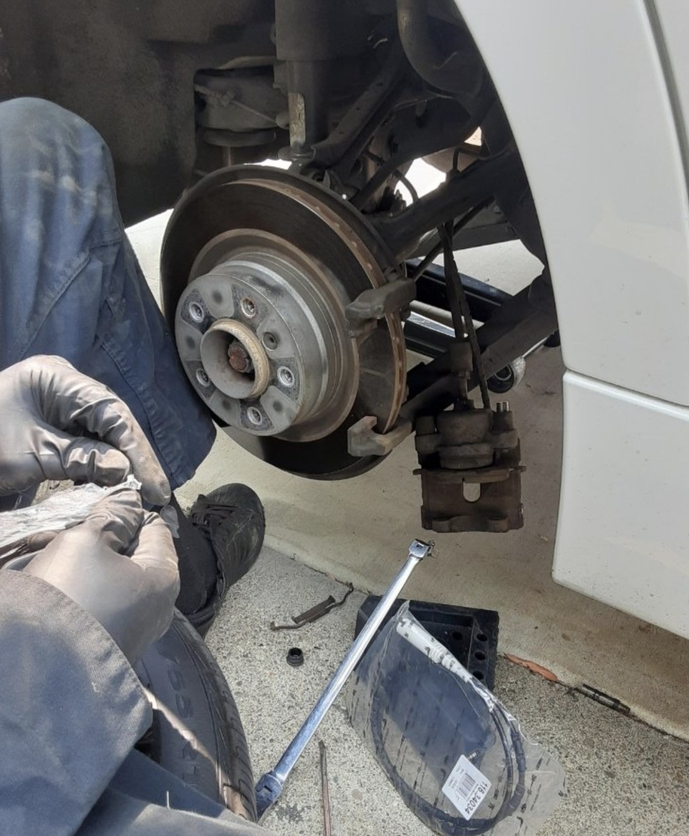 Huntington Beach mobile mechanic replacing a brake rotor curbside
